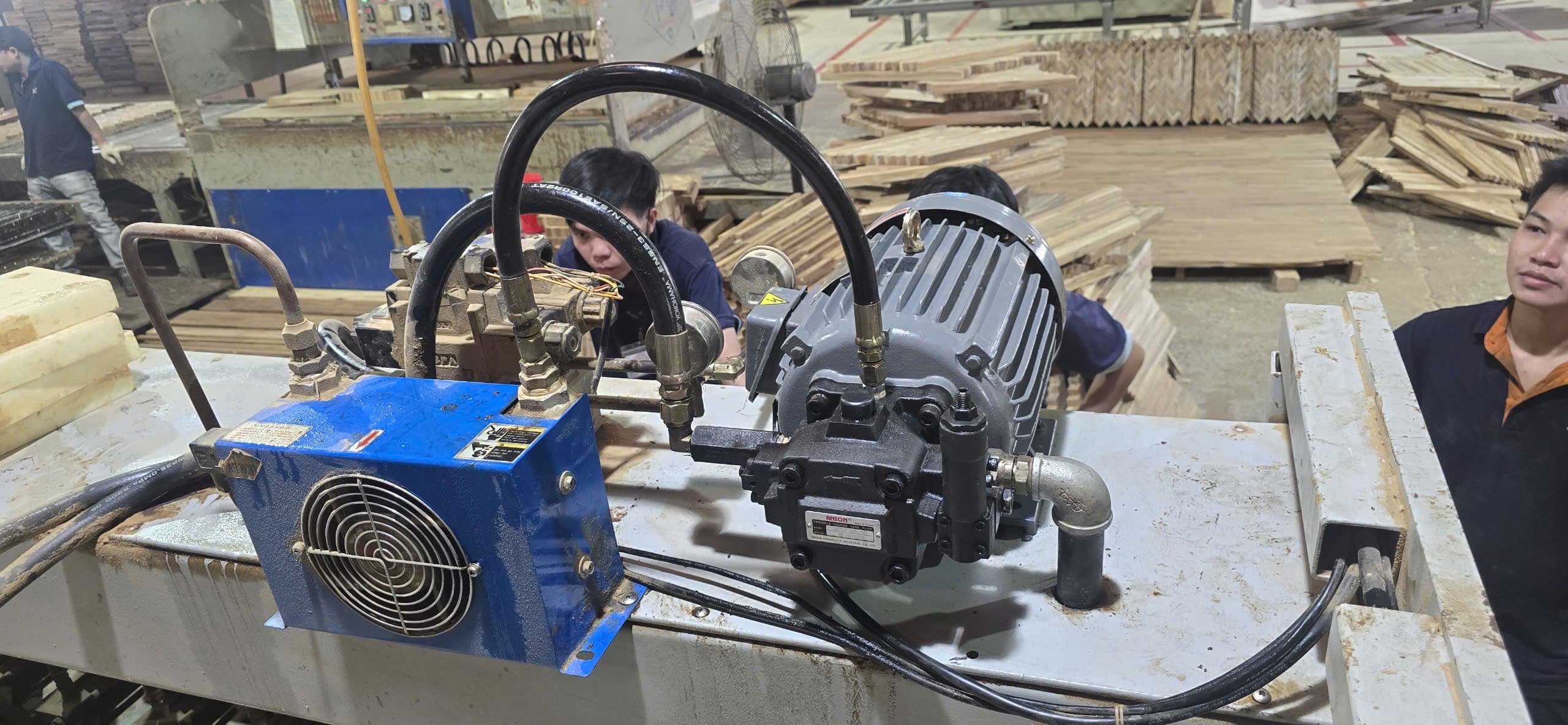 Engineer photographing wiring and PLC configurations at a workstation.